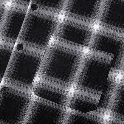 Close-up of black and white plaid flannel shirt fabric with pocket and buttons