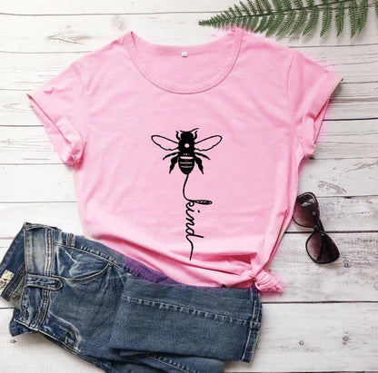Pink t-shirt with bee and 'be kind' graphic, paired with denim shorts and sunglasses