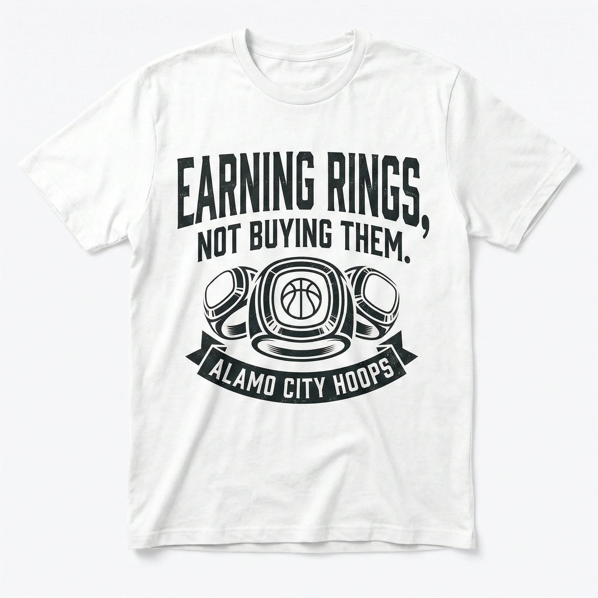 White t-shirt with 'Earning Rings, Not Buying Them. Alamo City Hoops' basketball graphic.