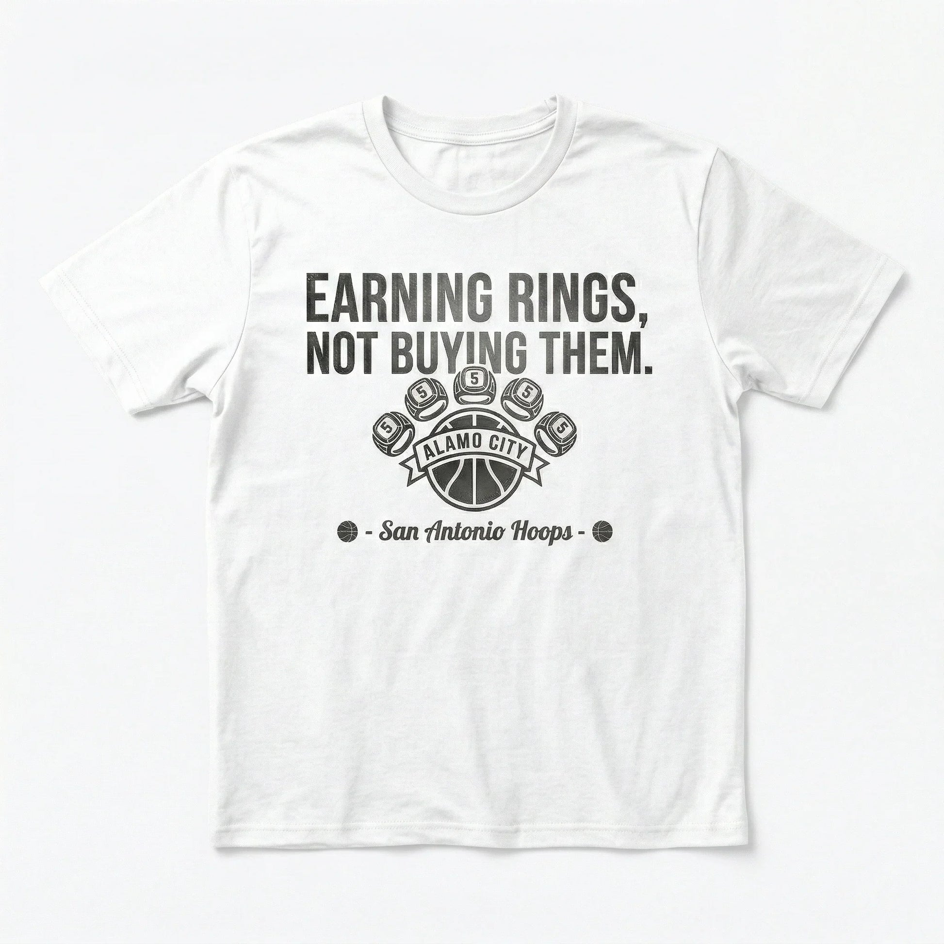 White t-shirt with "Earning Rings, Not Buying Them" basketball graphic and San Antonio Hoops text.