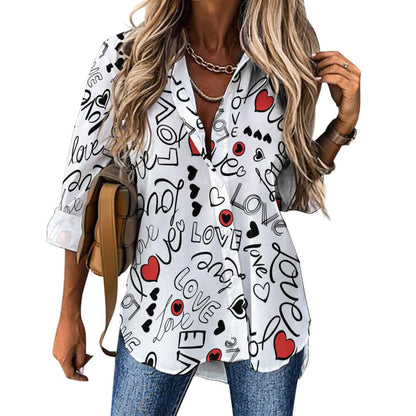 Woman in white button-up shirt with black 'love' script, red hearts, and casual jeans