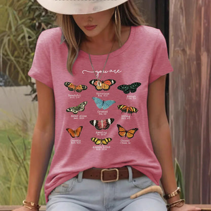 Woman in pink t-shirt with colorful butterfly graphics and uplifting words outdoors