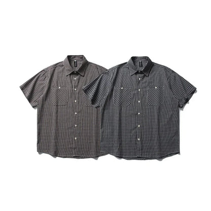 Two short sleeve plaid button-up shirts with chest pockets, side by side on white background.