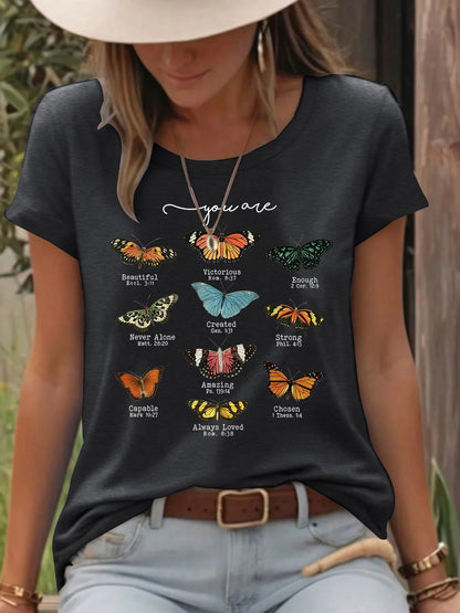 Woman wearing black t-shirt with colorful butterflies and inspirational Bible verses outdoors