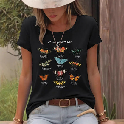 Woman wearing black t-shirt with colorful butterfly prints and inspirational text outdoors