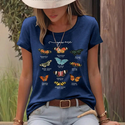 Woman wearing navy blue t-shirt with colorful butterfly graphic and positive affirmations outdoors