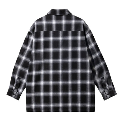Black and white plaid flannel shirt with long sleeves, shown from the back.
