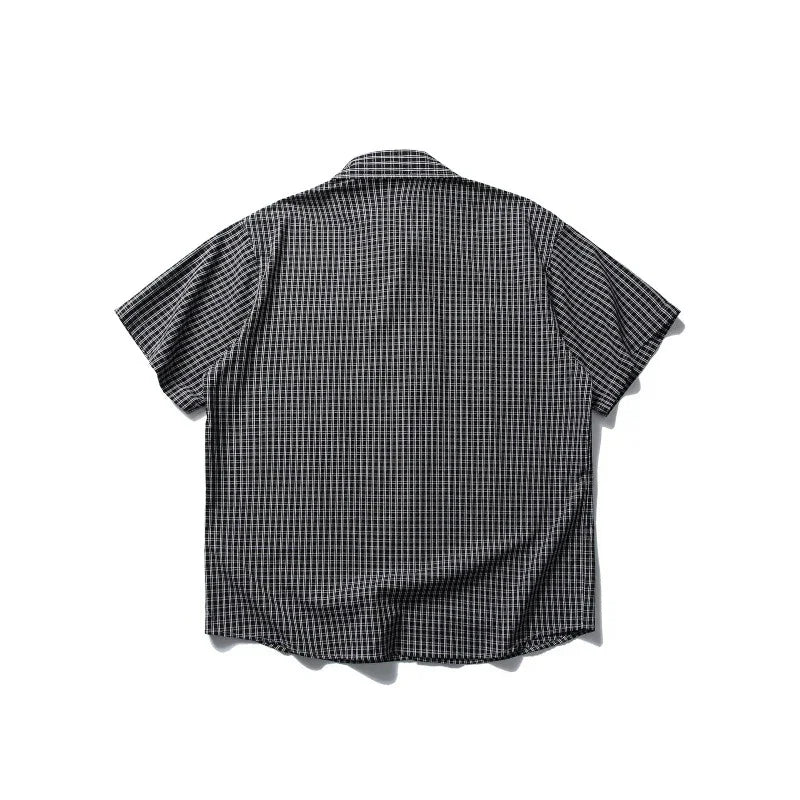 Black and white checkered short-sleeve shirt laid flat on white background