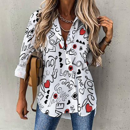 Woman wearing white button-up shirt with black 'love' letters, red hearts, and casual jeans